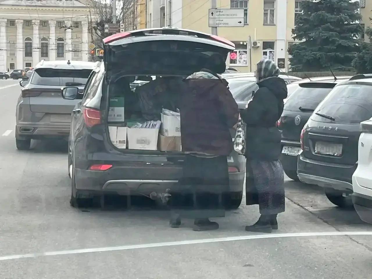 Мужчина в рясе раздает листовки у торгового центра