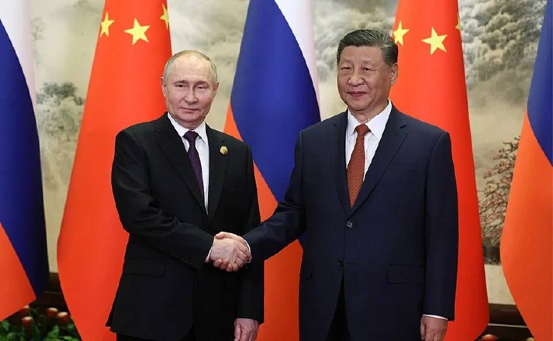 Владимир Путин и Си Цзиньпин пожимают руки на переговорах
