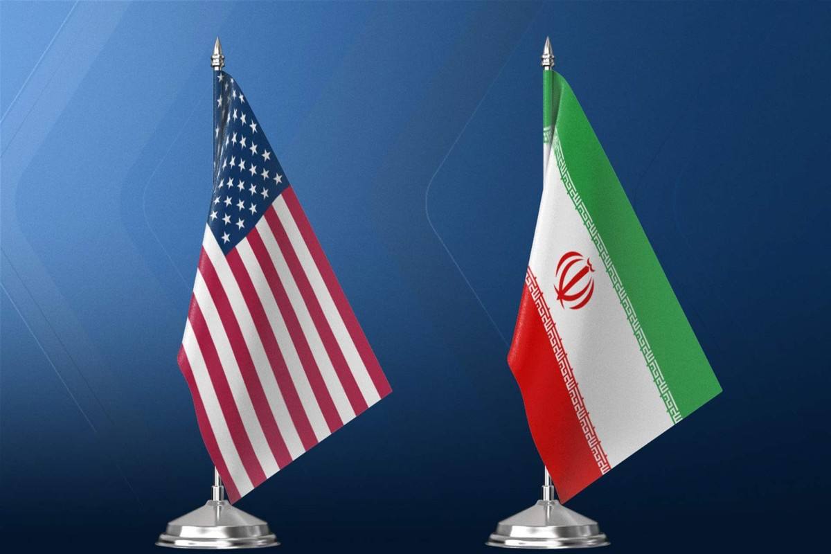 Флаги США и Ирана на фоне переговорного стола