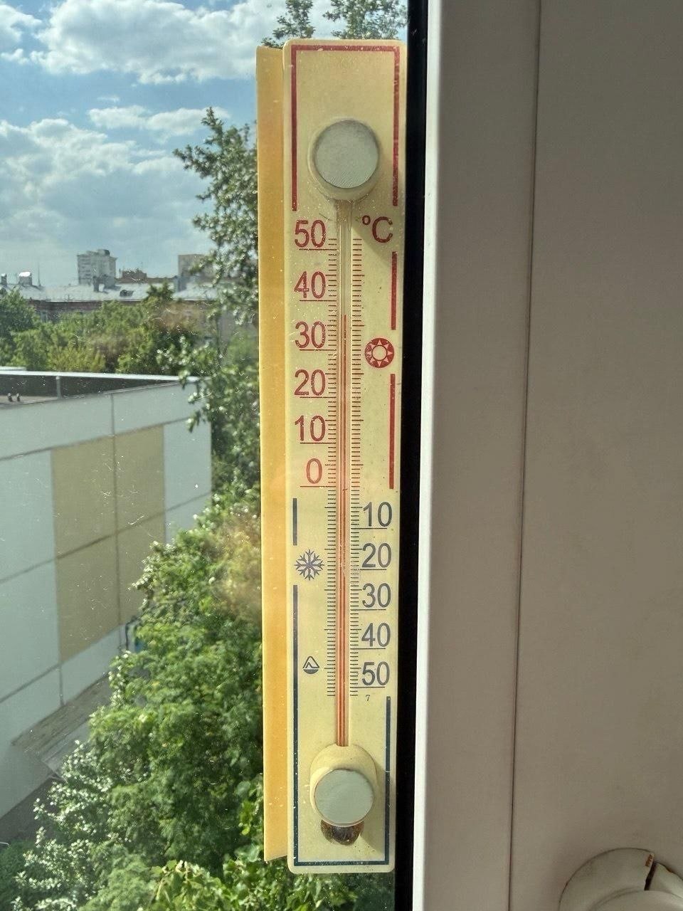 Термометр показывает +37 градусов на фоне солнечного неба в Москве