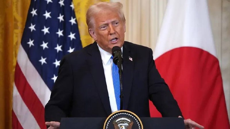 Дональд Трамп выступает с трибуны на фоне флага США