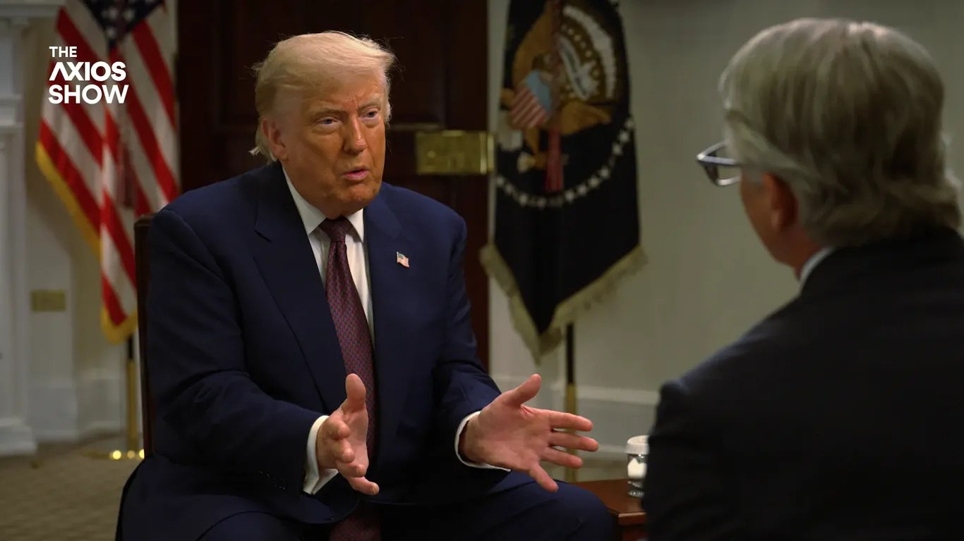 Дональд Трамп выступает с трибуны на фоне флагов США