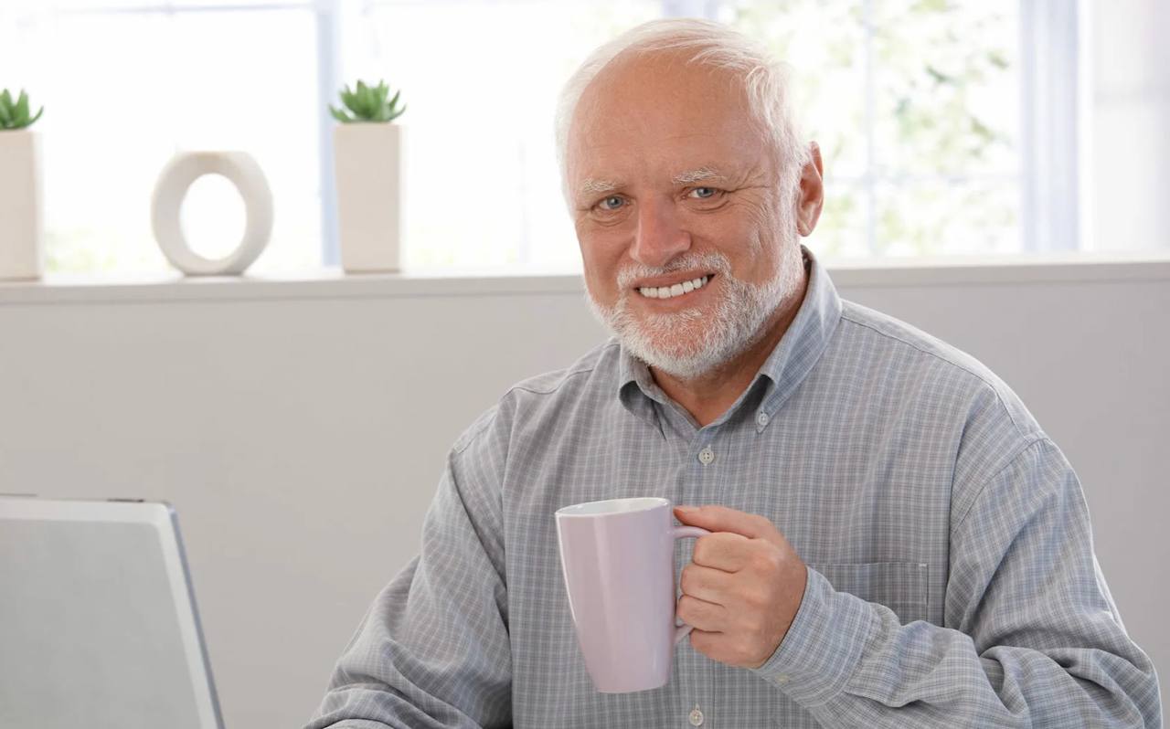 Пожилой мужчина с характерной улыбкой на фоне венгерского флага