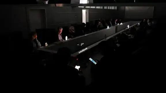 Темный зал иранского парламента с силуэтами депутатов