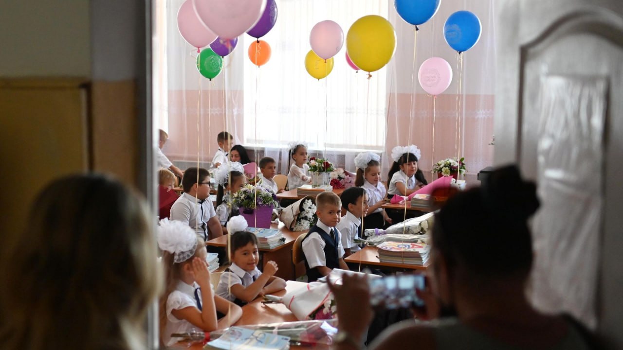 Ученик начальной школы с рюкзаком у доски
