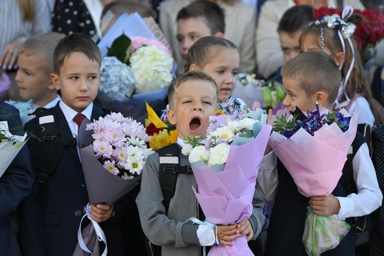 Родители ведут детей в школу первого сентября