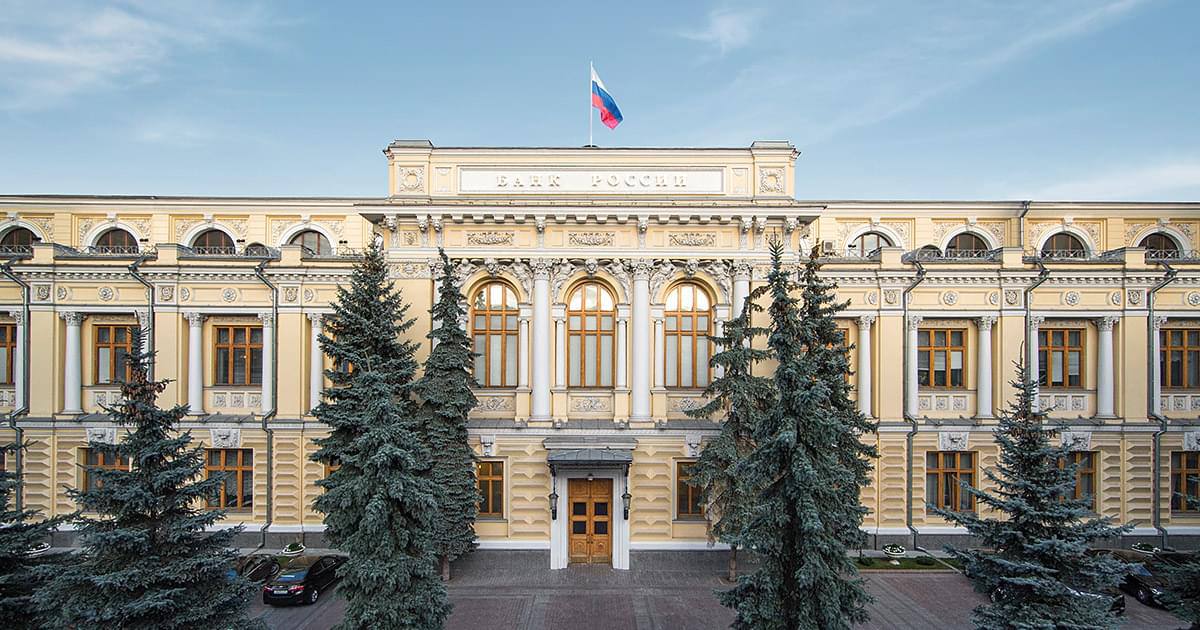 Кувалда и доллары на фоне здания Центробанка