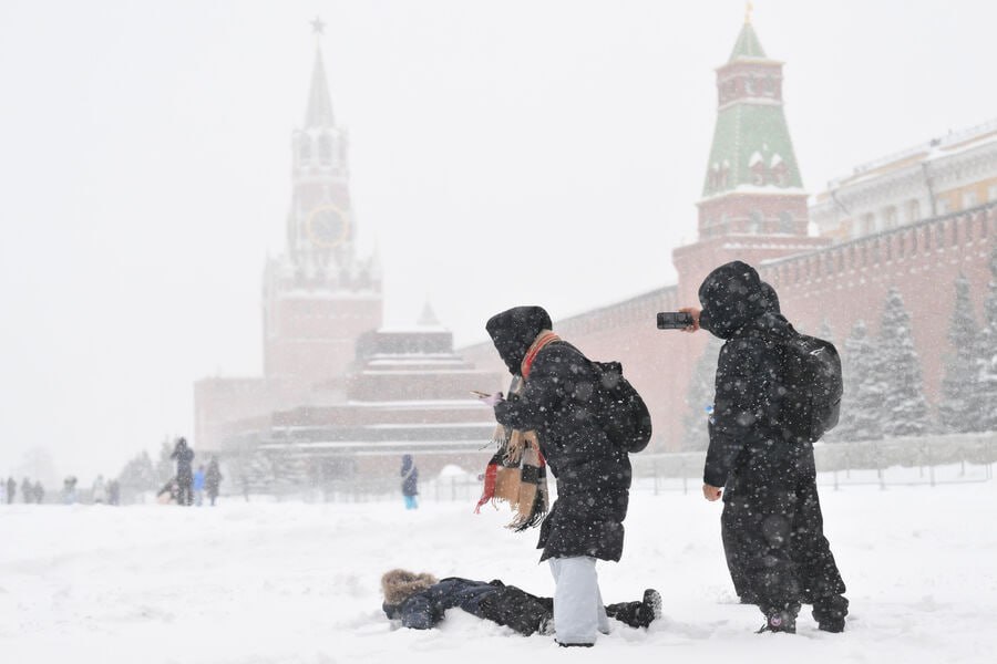 Снегопад в Москве на фоне городских зданий